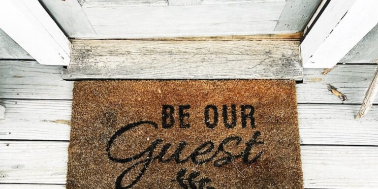 welcome mat at short term rental welcoming reader to be our guest.