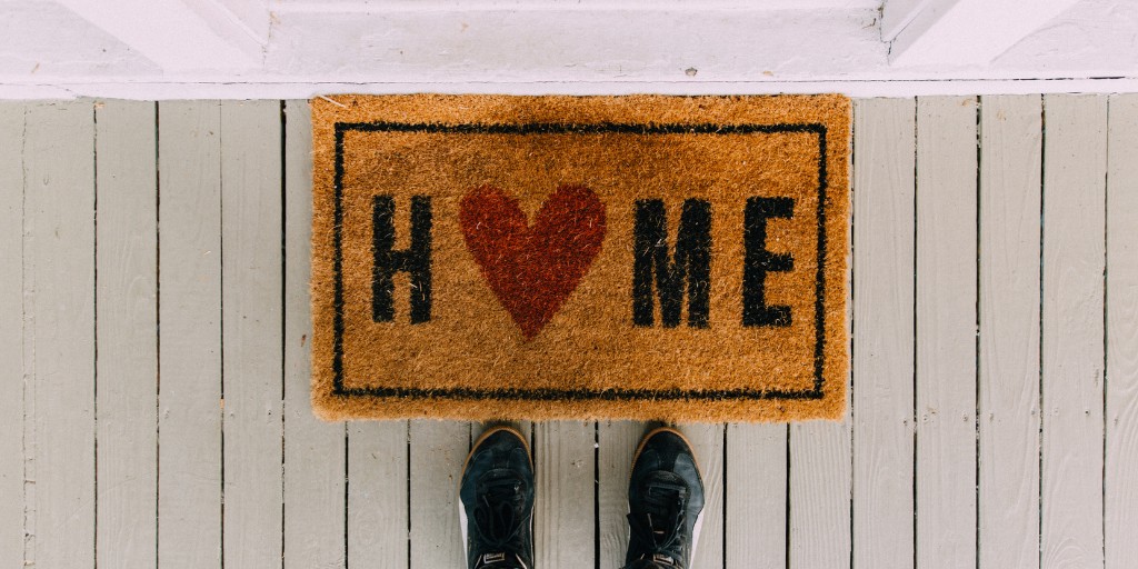 Overhead shot of a doormat that says "Home"